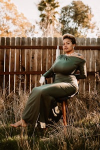 a woman in a green dress sitting on a chair